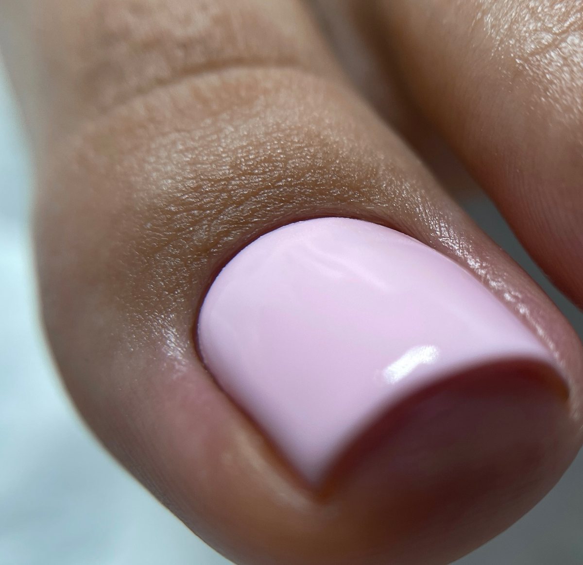 Pale pink gel pedicure with polish flush to the cuticle