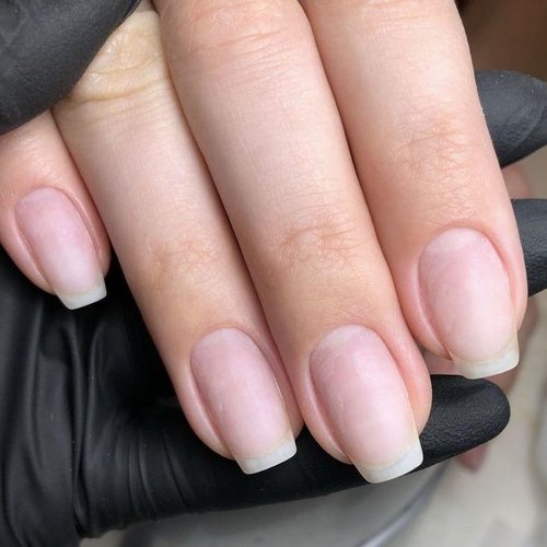 Sheer pink gel manicure, technician wearing black gloves